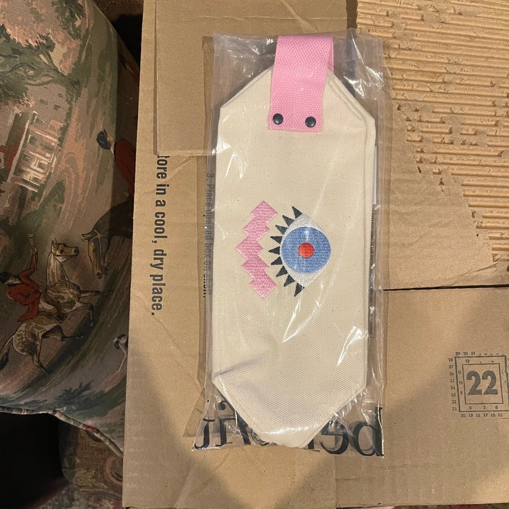 Benefit makeup bag NWT. Pink and cream canvas pouch with raised eye design.